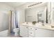 Bright bathroom featuring double sinks, white cabinets, and a shower-tub combo at 605 Lakeview Ave, Wake Forest, NC 27587