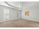 Spacious bedroom with plush carpet, ceiling fan, tray ceiling and windows providing plenty of natural light at 605 Lakeview Ave, Wake Forest, NC 27587