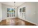 Cozy dining area featuring hardwood floors, a chandelier, and plenty of natural light from two large windows at 605 Lakeview Ave, Wake Forest, NC 27587