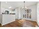 Bright dining area with wood floors, white trim, large windows with plantation shutters, and an open kitchen view at 605 Lakeview Ave, Wake Forest, NC 27587