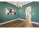 Dining room showcasing modern chandelier, hardwood floors, wall art, and open access to the kitchen at 605 Lakeview Ave, Wake Forest, NC 27587