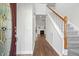 Bright foyer with wood floors, a staircase with carpet runner, and a view into the living room with fireplace at 605 Lakeview Ave, Wake Forest, NC 27587