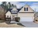 Charming yellow home featuring well-maintained landscaping, a two-car garage and a welcoming entryway at 605 Lakeview Ave, Wake Forest, NC 27587