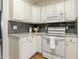 Functional kitchen featuring white cabinets, granite countertops, updated appliances and trendy backsplash at 605 Lakeview Ave, Wake Forest, NC 27587