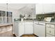 Charming kitchen with white cabinetry, granite countertop island, stainless dishwasher, and adjacent living area at 605 Lakeview Ave, Wake Forest, NC 27587