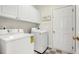 Laundry room featuring white appliances, checkerboard floors, and white cabinets at 605 Lakeview Ave, Wake Forest, NC 27587