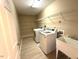 Bright laundry room with modern appliances, shelving, and utility sink for convenience at 6705 Somerknoll Dr, Durham, NC 27713