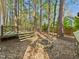 Backyard with stacked stone fire pit, wood deck, and lots of trees at 7117 Sandringham Dr, Raleigh, NC 27613