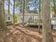 Backyard featuring a deck, wooded lot, and outbuilding at 7117 Sandringham Dr, Raleigh, NC 27613