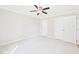 Neutral bedroom with ceiling fan, neutral carpet, and double door closet space at 7117 Sandringham Dr, Raleigh, NC 27613