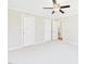 Bright bedroom with ceiling fan, neutral carpet, and multiple closet doors at 7117 Sandringham Dr, Raleigh, NC 27613