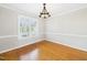Bright dining room with hardwood floors, chandelier, and a large window at 7117 Sandringham Dr, Raleigh, NC 27613