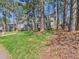Home featuring a green lawn, mature trees, and classic architecture with dark shutters at 7117 Sandringham Dr, Raleigh, NC 27613