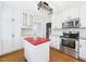 Bright kitchen features white cabinets, modern appliances, and a red island countertop at 7117 Sandringham Dr, Raleigh, NC 27613