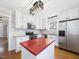 Bright kitchen with white cabinets, stainless appliances, and a red island countertop at 7117 Sandringham Dr, Raleigh, NC 27613