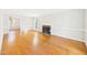 Bright living room boasts hardwood floors, fireplace with brick surround, and classic white trim at 7117 Sandringham Dr, Raleigh, NC 27613