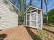 Backyard storage shed with double door entry in wooded lot at 7117 Sandringham Dr, Raleigh, NC 27613