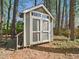Backyard storage shed with a double door entry and window pane transom at 7117 Sandringham Dr, Raleigh, NC 27613