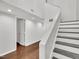 Clean hallway and staircase with hardwood floors, white walls, and modern lighting at 717 E Millbrook Rd, Raleigh, NC 27609