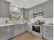 Modern kitchen featuring stainless steel appliances, gray cabinets, and a bright window at 717 E Millbrook Rd, Raleigh, NC 27609