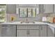 Modern kitchen featuring stainless steel appliances, gray cabinets, and a bright window at 717 E Millbrook Rd, Raleigh, NC 27609