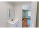 Bathroom with a white vanity and mirror, with a glimpse into the adjacent bedroom at 72 Edgemont Ave, Roxboro, NC 27573