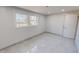 An empty room with natural light, neutral color walls, sleek gray tile flooring, and a closet at 72 Edgemont Ave, Roxboro, NC 27573
