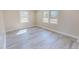 Bright bedroom featuring wood-look flooring and natural light from two large windows at 72 Edgemont Ave, Roxboro, NC 27573