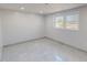 An empty room with natural light, neutral color walls, and sleek gray tile flooring at 72 Edgemont Ave, Roxboro, NC 27573