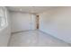 An empty room with natural light, neutral color walls, sleek gray tile flooring, and a door to the hallway at 72 Edgemont Ave, Roxboro, NC 27573