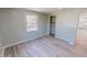 Light-filled bedroom with modern floors, a window and a glimpse into the kitchen area at 72 Edgemont Ave, Roxboro, NC 27573