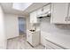 View of a kitchenette featuring a stainless steel sink, tiled backsplash, and white cabinets at 72 Edgemont Ave, Roxboro, NC 27573