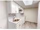 View of a kitchenette featuring a stainless steel sink, tiled backsplash, and white cabinets at 72 Edgemont Ave, Roxboro, NC 27573