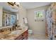 Bright bathroom featuring a granite countertop vanity, decorative shower curtain, and tiled floors at 7317 Mill Ridge Rd, Raleigh, NC 27613