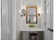 Well-lit vanity area with a marble countertop, decorative mirror, sconces, and a stool, adding a touch of elegance at 7317 Mill Ridge Rd, Raleigh, NC 27613