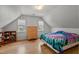 Bright attic bedroom with hardwood floors and a comfortable bed, offering a cozy and private space at 7317 Mill Ridge Rd, Raleigh, NC 27613