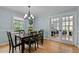 Bright dining area with hardwood floors and view of the living room through French doors at 7317 Mill Ridge Rd, Raleigh, NC 27613