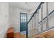 Inviting entryway featuring a blue door, wooden staircase with white railings, and a bench at 7317 Mill Ridge Rd, Raleigh, NC 27613