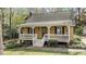 Home featuring a covered front porch with white railings and stained shutters, offering a cozy and classic appeal at 7317 Mill Ridge Rd, Raleigh, NC 27613