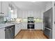 Modern kitchen featuring stainless steel appliances, white cabinetry, and granite countertops at 7317 Mill Ridge Rd, Raleigh, NC 27613