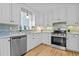 Well-lit kitchen featuring stainless steel appliances, granite countertops, and white cabinetry at 7317 Mill Ridge Rd, Raleigh, NC 27613