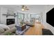 Bright living room with a white brick fireplace, hardwood floors, and open access to the dining area at 7317 Mill Ridge Rd, Raleigh, NC 27613