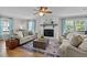 Cozy living room with a brick fireplace, ceiling fan, hardwood floors, and comfortable seating at 7317 Mill Ridge Rd, Raleigh, NC 27613