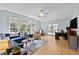 Sunlit living room boasts ample windows, a blue sectional sofa, and a dedicated workspace, creating a versatile living space at 7317 Mill Ridge Rd, Raleigh, NC 27613