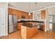 Well-equipped kitchen with stainless steel appliances, a granite island, and wooden cabinetry at 7819 Acc Blvd, Raleigh, NC 27612
