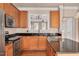 Open kitchen with wood cabinets, a granite countertop, and an open view to an adjacent living area at 7819 Acc Blvd, Raleigh, NC 27612