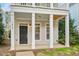 Detailed view of the front porch with white columns and a black front door with sidelight windows at 7819 Acc Blvd, Raleigh, NC 27612