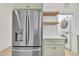 A view of a stainless steel refrigerator and the laundry appliances in the utility closet at 8 Nottingham Pl, Smithfield, NC 27577