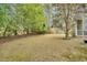 Backyard featuring mature trees, a manicured lawn, and glimpses of the home's exterior at 801 Noconia Pl, Fuquay Varina, NC 27526