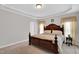 Main bedroom featuring a tray ceiling and decorative wood bed frame at 801 Noconia Pl, Fuquay Varina, NC 27526